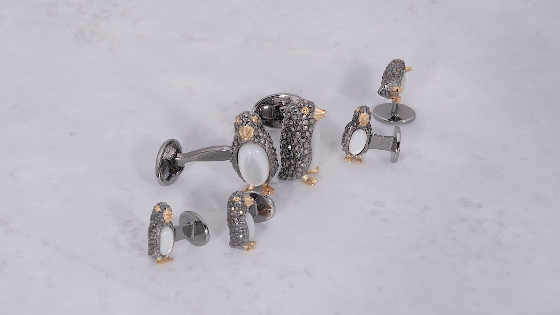 Video of a 180 degree view of Jan Leslie's Gemstone Penguin Sterling Silver Cufflinks and Tuxedo Studs on marble background. 