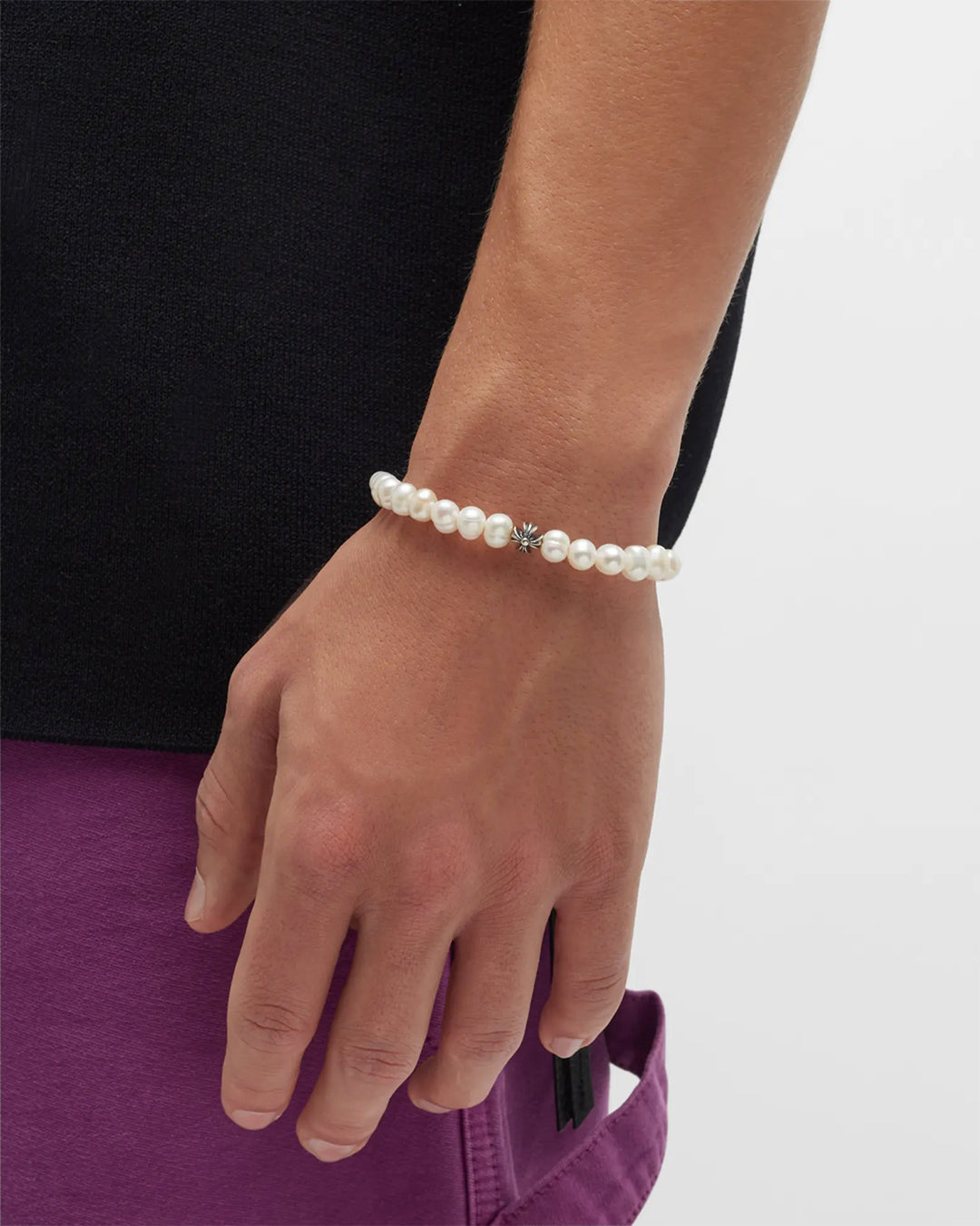 Male model wearing Jan Leslie's Men's Freshwater Pearl Stretch Bracelet with Sterling Silver Fluted Star Spacer. 