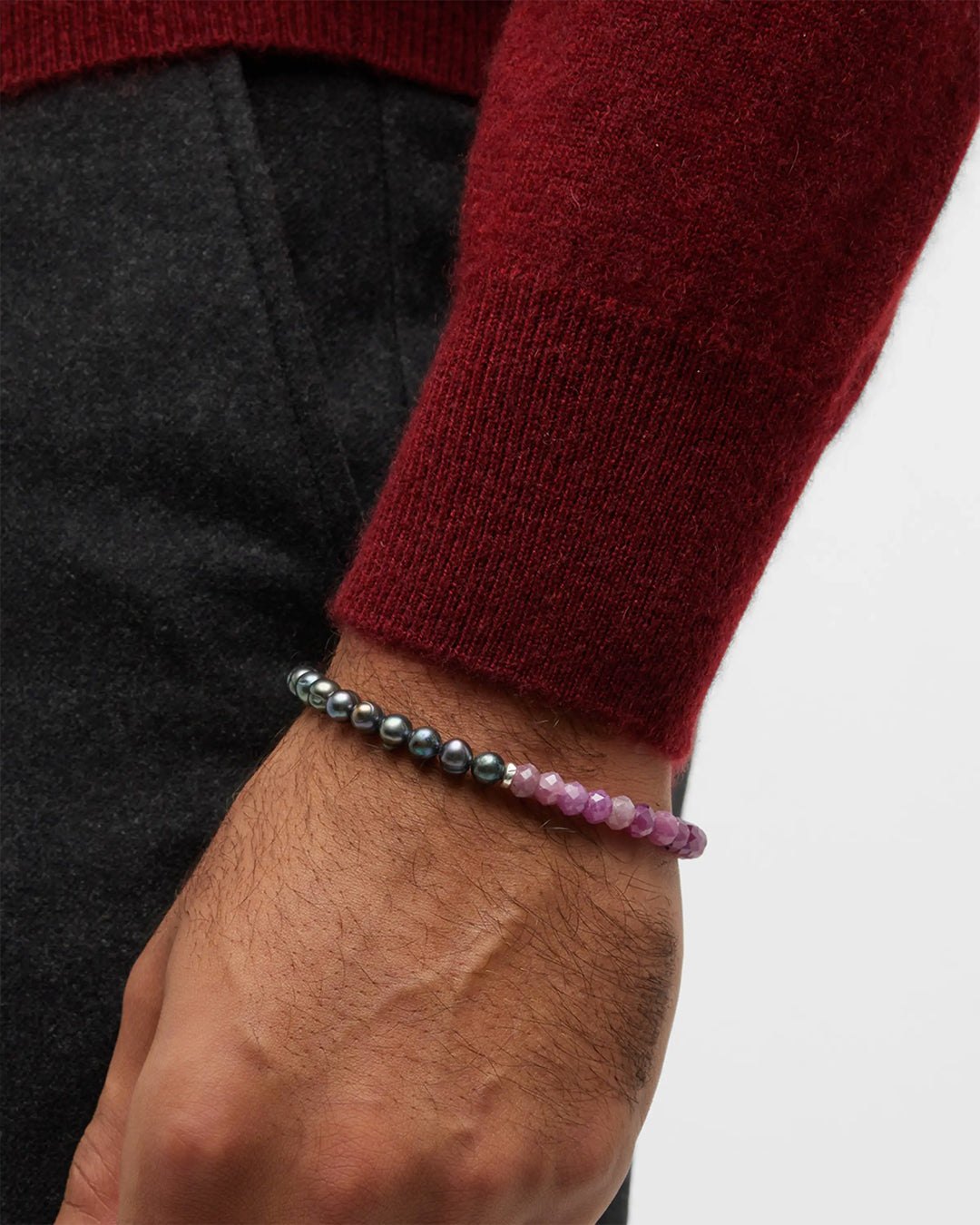 Close up of male models wrist wearing Jan Leslie's Men's Red Ruby and Freshwater Pearls Split Beaded Bracelet. 