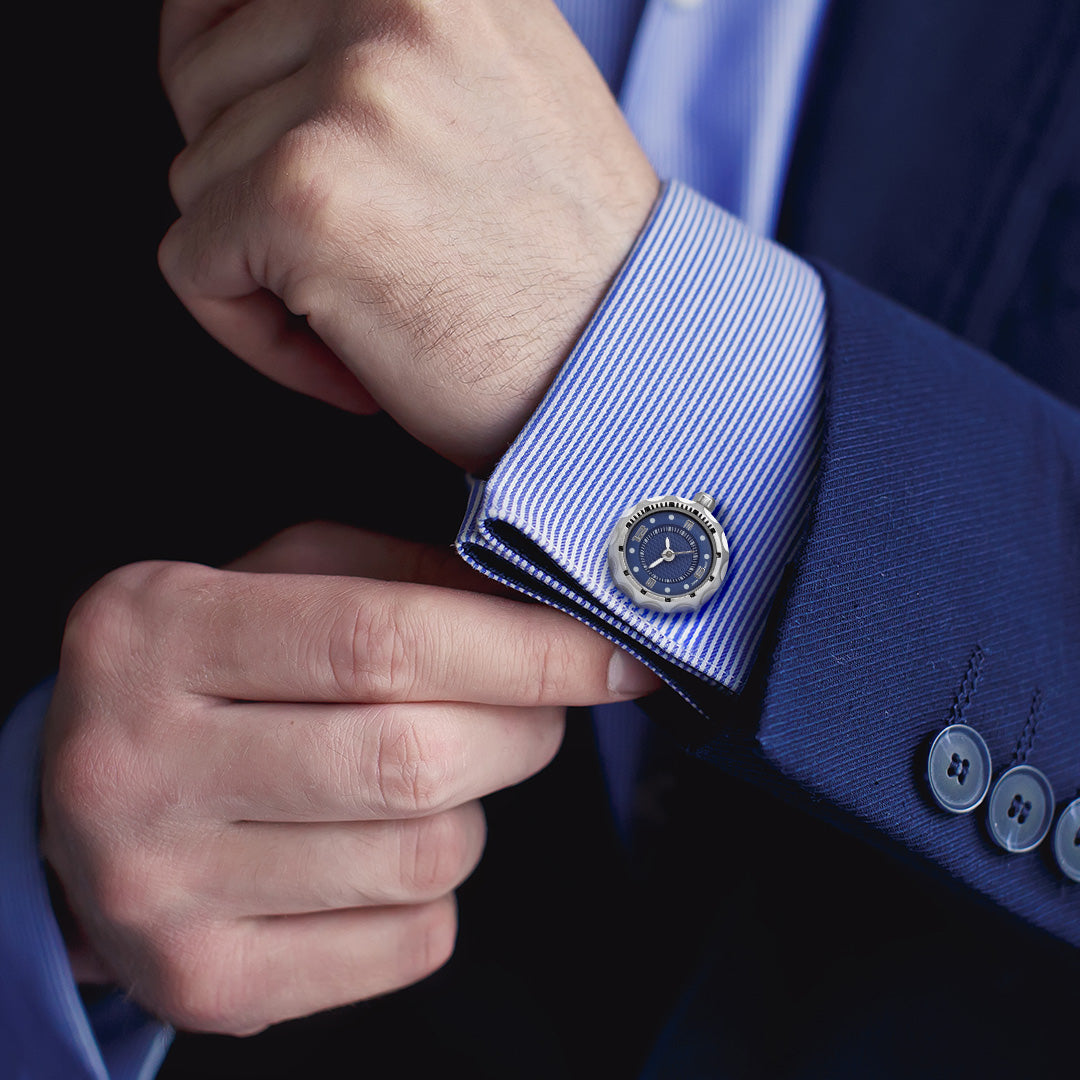 Male model wearing Miniature Face Watch Stainless Steel & Sterling Silver Cufflinks in blue on a blue and white striped cuffed shirt with dark blue sports coat. 