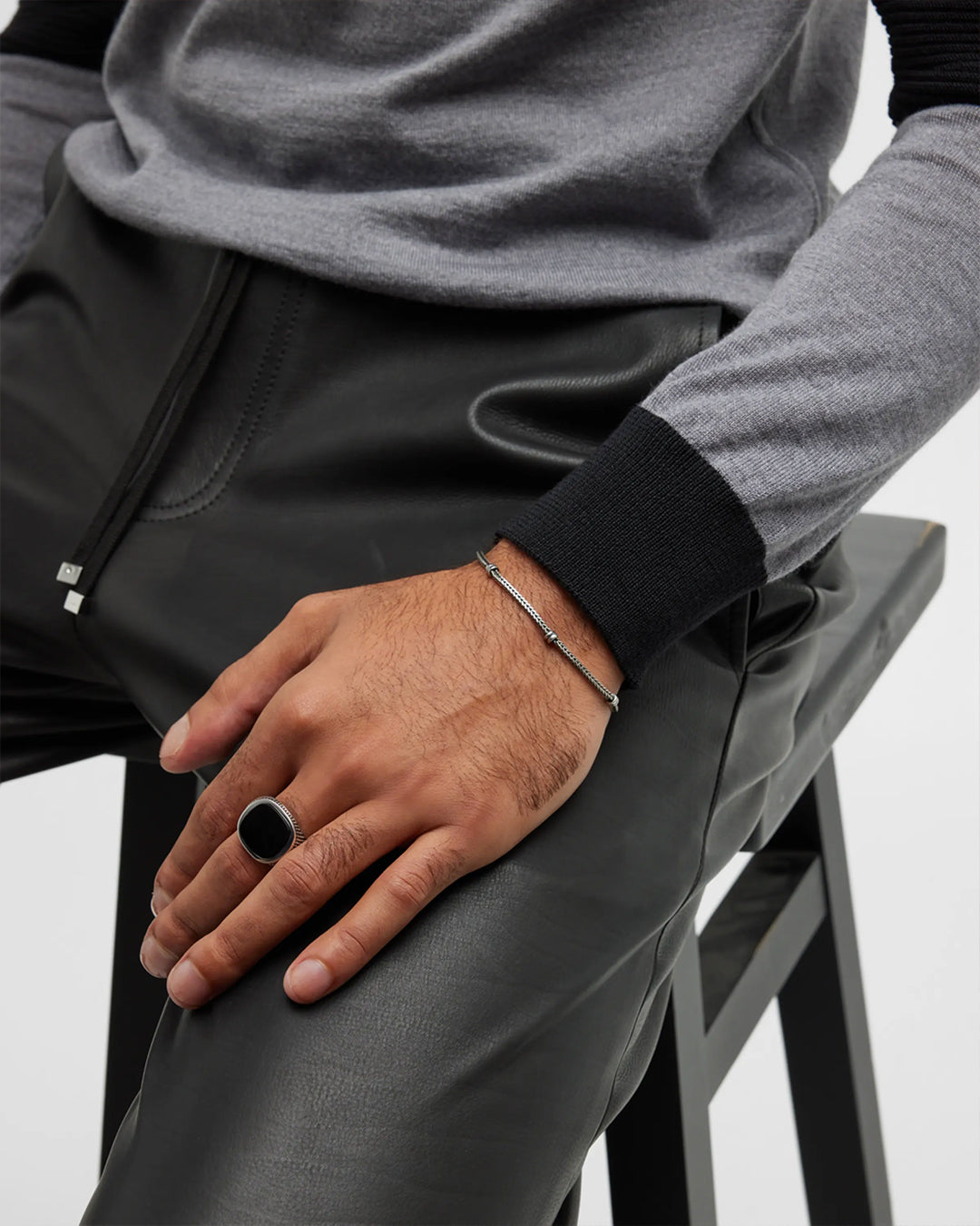 Close up of male models hand wearing the Cross Etched Black Onyx Sterling Silver Ring. 