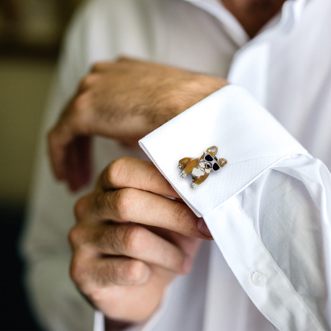 Close up of a male models wrist wearing the French Bulldog with Hand-painted Enamel & Sterling Silver Cufflinks in brown with black glasses on a white cuffed shirt.