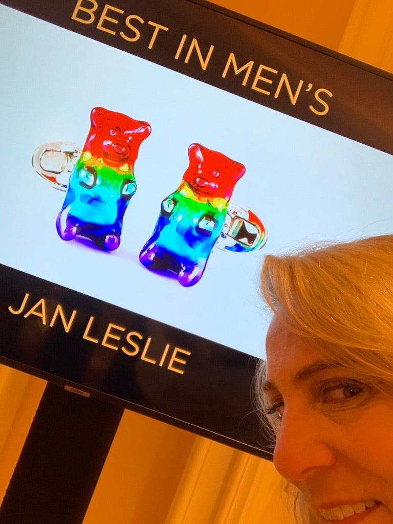 Jan Leslie in front of a digital display showcasing her AWARD WINNING Rainbow Enamel Gummy Bear Sterling Silver Cufflinks for  the "Best In Men's" category at the Couture Design Awards in Las Vegas, NV. 